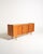 Teak sideboard with five drawers, two sliding doors, and internal compartments with shelves, featuring tapered oak legs...