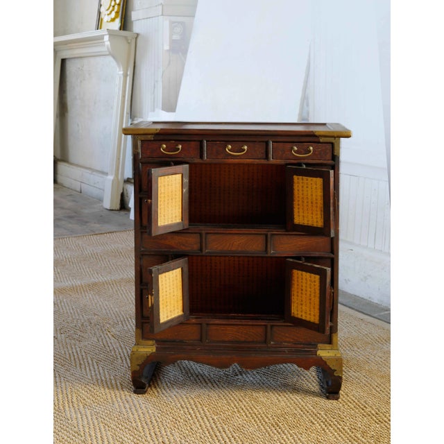 Antique Asian cabinet with compartments. Brass corner reinforcements, handles and decorative detail. The doors and back of...