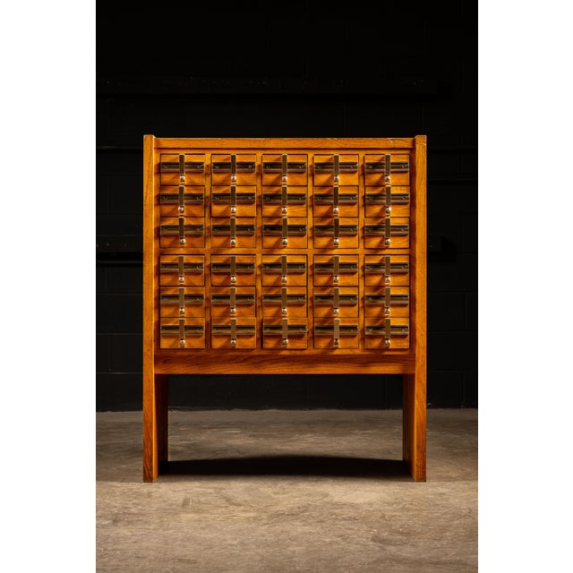 Vintage freestanding blonde oak library card catalog with attached leg supports, likely from the 1950s. Previous ownership...