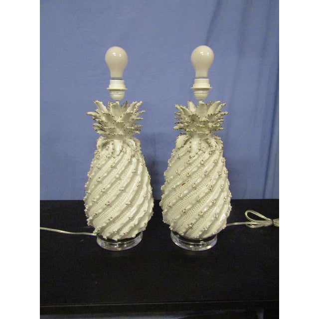 Stunning Pair of Ceramic Lamps on a Lucite base. The Pair have exceptional detail, white glaze and drum shades . The Pair...