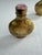 A decorative pair of vintage Chinese brass snuff bottles accented with pink tourmaline stoppers. Each bottle features...