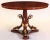 and Italian mahogany and parcel-gilt center table with a circular top above triple addorsed dolphins on a triform base,...
