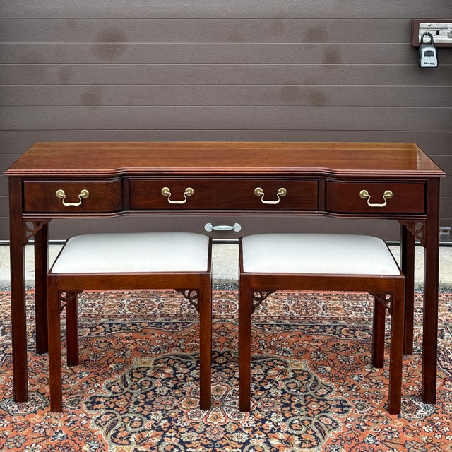 A vintage Tradition House Chippendale solid cherry 3 drawer console table with pair of benches featuring a serpentine...