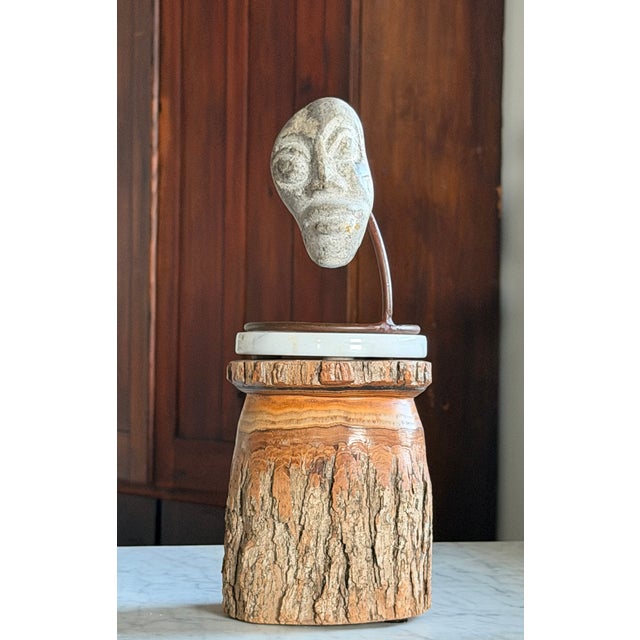 A compelling carved stone face, mounted on a custom welded steel base. Of Indonesian origin, circa 1970s, the sculpture...