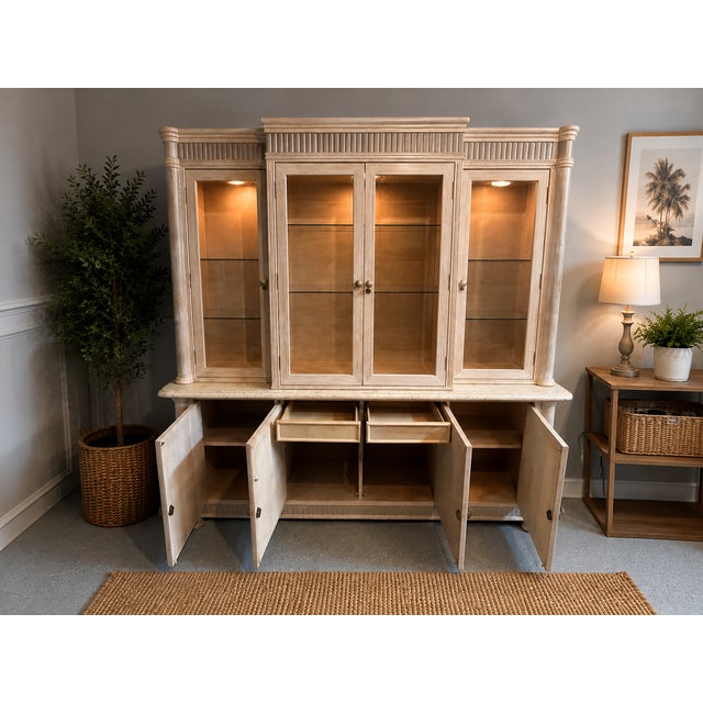 Two-piece display hutch and buffet cabinet beautifylly crafted in a soft neutral finish with timeless architectural...