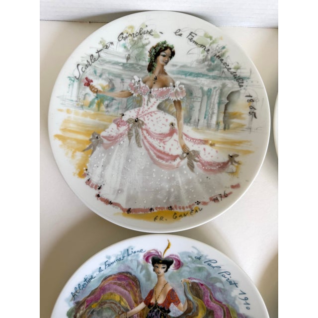 Here is a set of four vintage 1970s French Limoges porcelain plates from D’Arceau-Limoges’ “Les Femmes du Siècle” (Women...