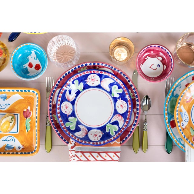 The colorful blue and red Campagna Pesce Salad Plate features whimsical handpainted fish swimming among green algae. Care...