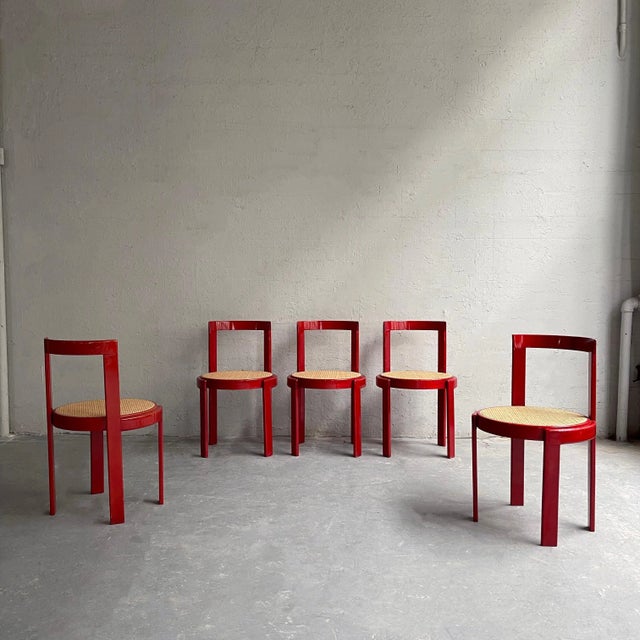 Set of six, Italian modernist dining chairs feature circular, lipstick red stained beech frames with natural caned seats.