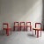 Set of six, Italian modernist dining chairs feature circular, lipstick red stained beech frames with natural caned seats.