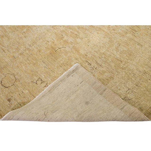 Beautiful antique Tabriz style hand-knotted wool rug with a tan field. This piece has a beige and brown accent in an all-...