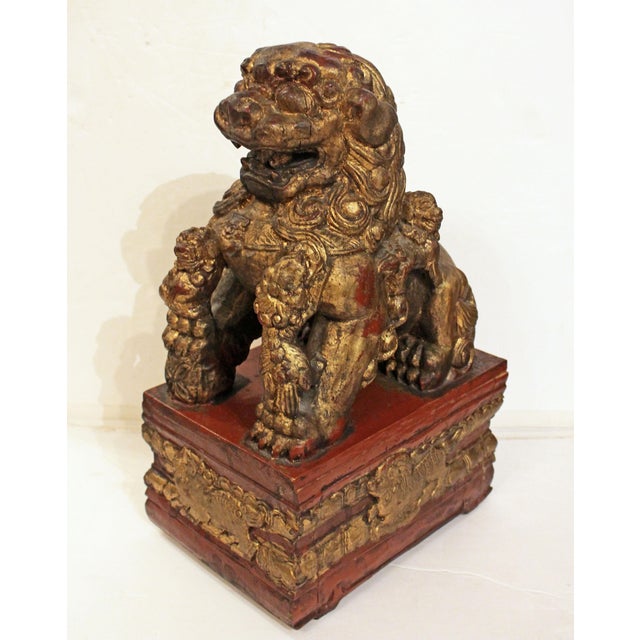 Early-mid 20th century carved, red lacquer and gilt female foo lion, Chinese. Attached to conforming hollow stand base...