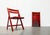 4 Mid Century folding chairs in red. Simple folding chairs made of wood. Particularly eye-catching is the high-quality...