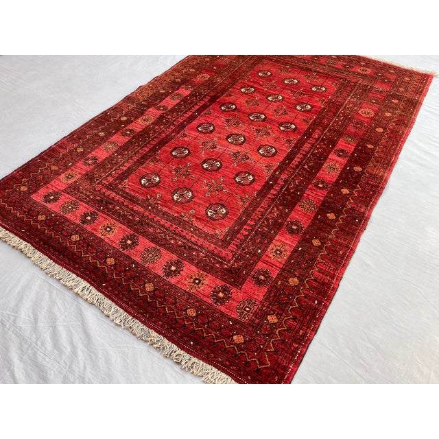 A vintage Afghan Ersari Turkmen rug in an unusually soft, rose-tinged colorway — rows of small quartered güls with ivory...