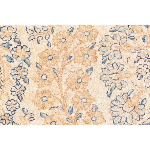 An early 20th century Persian Kirman (Kerman) antique rug, the sand field with an unusual mirrored pattern of thick...