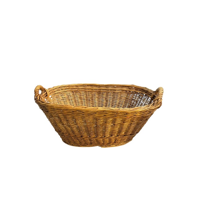 A beautifully handwoven French wicker basket showcasing timeless provincial charm and rustic craftsmanship. Featuring an...