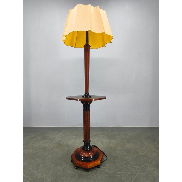 Elegant art deco floor lamp produced in italy during the 1940s. The lamp features a sculptural wooden column with fluted...