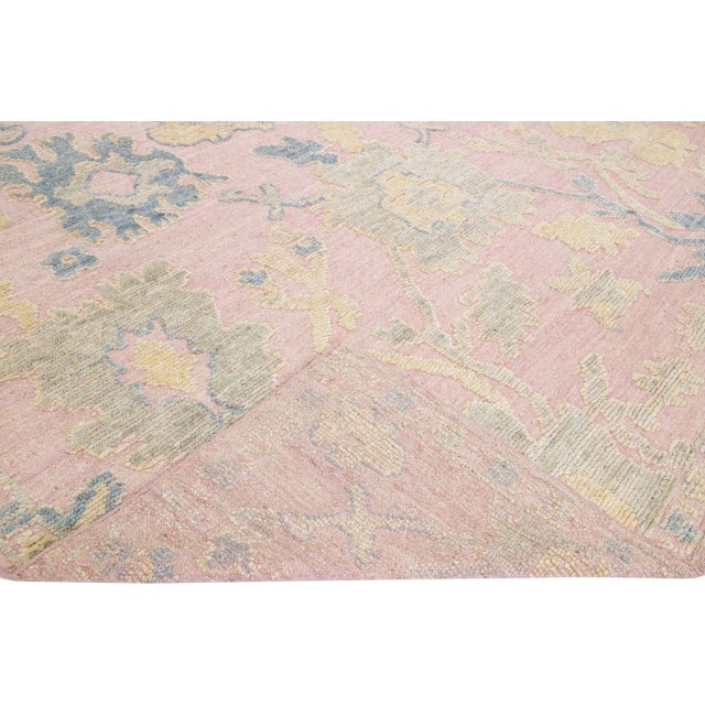Beautiful modern Oushak style hand-knotted wool rug with a light pink field. This piece has yellow and blue accents that...