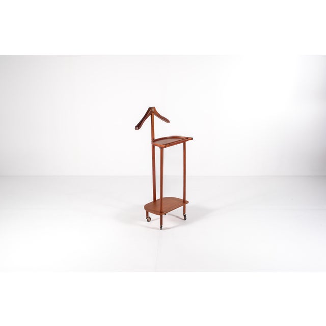 A vintage mid-century teak valet stand from the 1960s. Perfect for organizing clothing and accessories. It features a...
