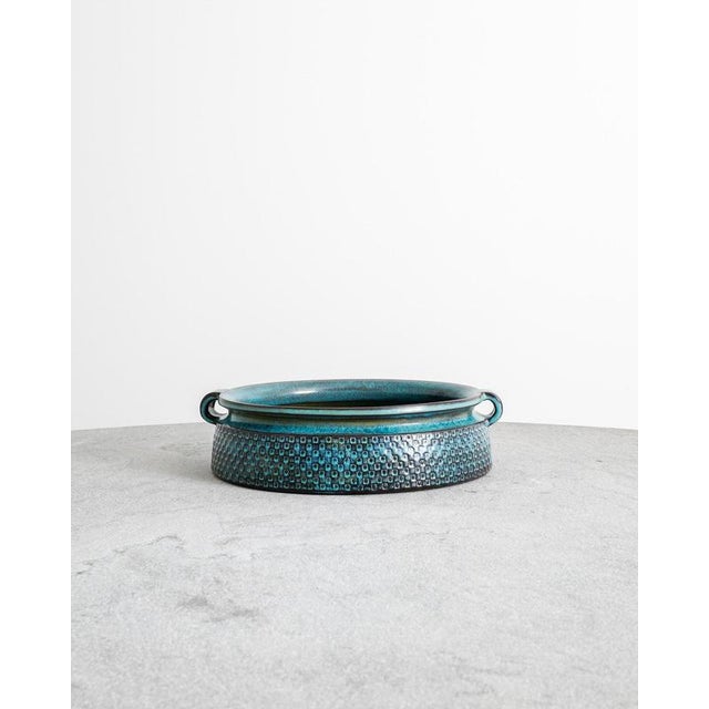 A rare and unique oversized swedish mid century stoneware bowl with handles in a decorative and characteristic blue-brown...