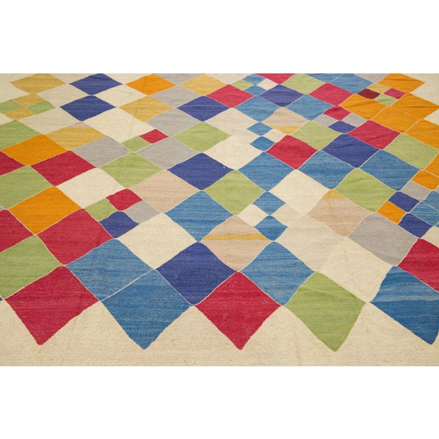 Beautiful modern Kilim flat-weave wool rug in a beige color field with multicolor accents in a gorgeous Abstract design....