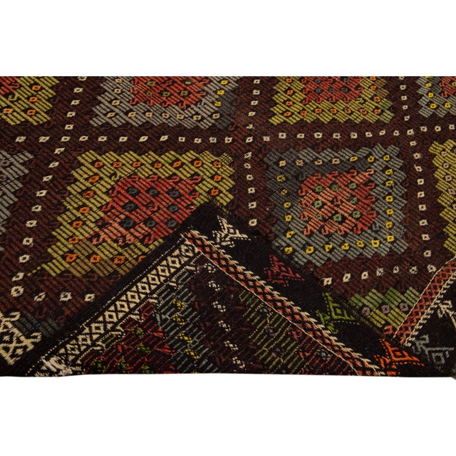 Beautiful vintage Persian Soumak handmade wool rug with a burnt orange field. This piece has a multi-color accent in an...