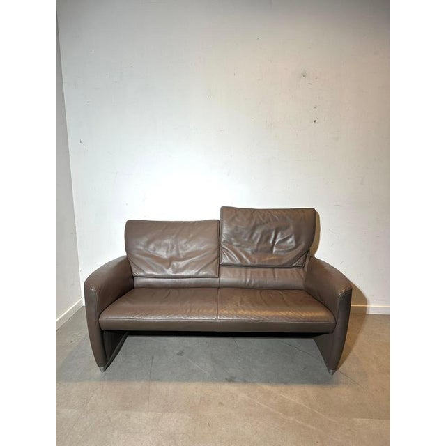 Compact high-end design sofa by Jori , executed in quality taupe-brown leather and paired with a matching...