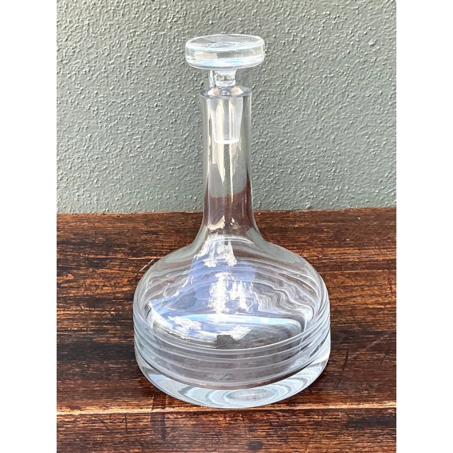 This vintage clear glass decanter brings understated mid-century elegance to any bar cart or dining table. The flared,...
