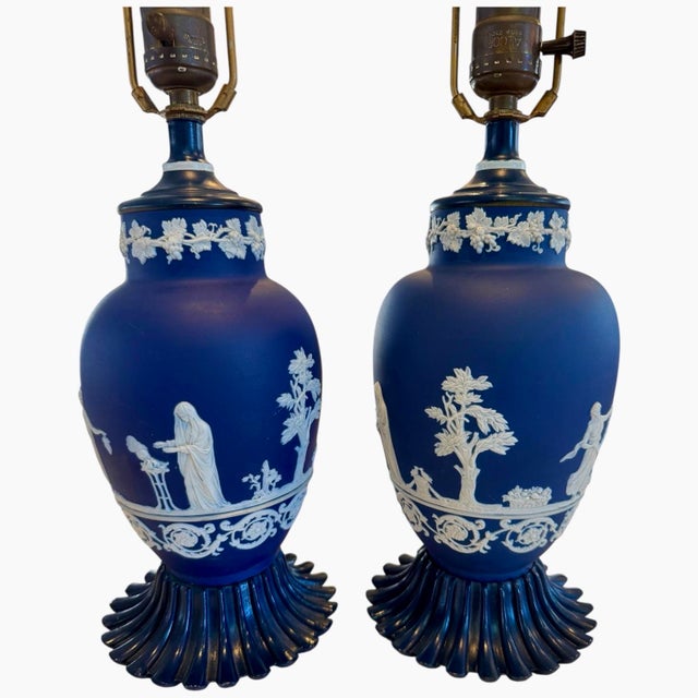 A striking pair of vintage cobalt blue jasperware table lamps featuring crisp white neoclassical relief decoration. These...