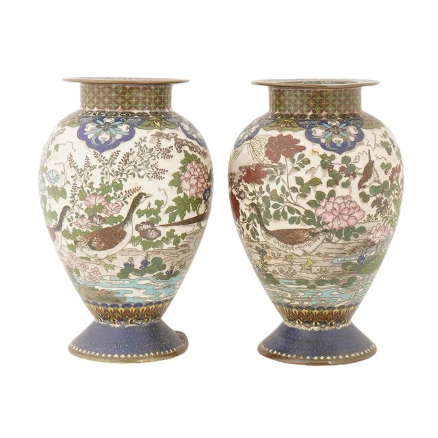 This finely matched pair of Japanese cloisonne enamel vases, dating to the Meiji period circa 1880 to 1890, represents...