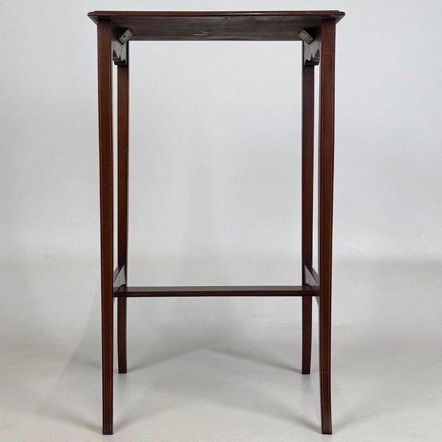 A charming and beautifully crafted early 20th-century English Edwardian side table, finely constructed in mahogany and...