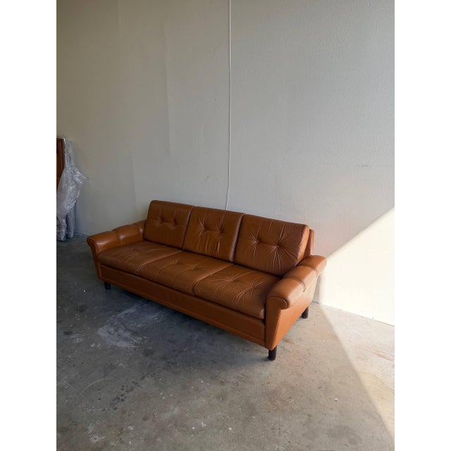 Beautiful vintage Danish leather sofa featuring classic Mid-Century Modern lines and rich cognac-tone leather upholstery....
