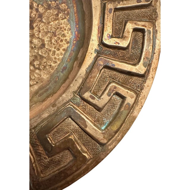 A handsome, hammered copper vide poche. Features a round copper vessel with Greek key decorations to the outer rim. Hand...