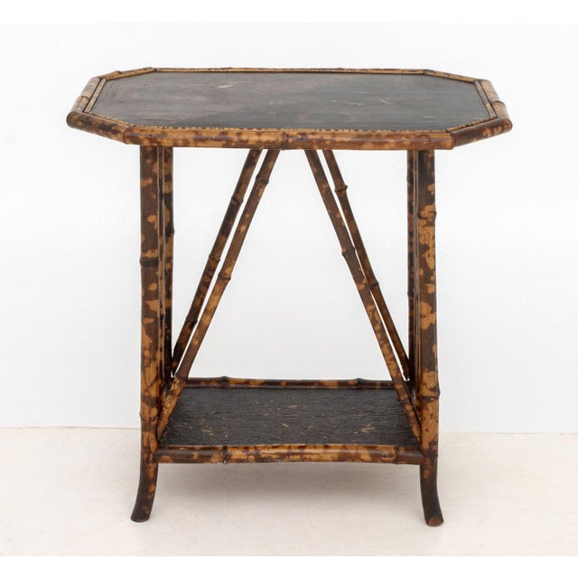 Chinoiserie Lacquered Bamboo Two-Tier Side Table, the black lacquer top with painted floral design, the bamboo frame with...
