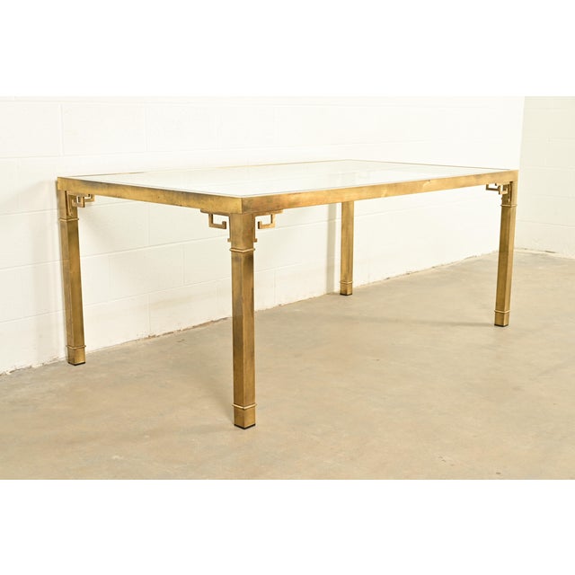 An exceptional mid-century modern Hollywood Regency dining table By Mastercraft USA, 1970s Brass frame with Greek Key...