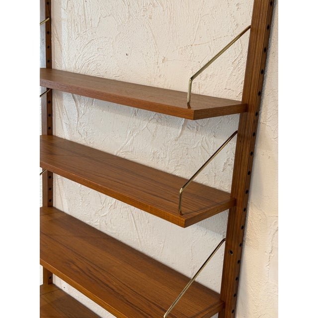 Elegant vintage Danish mid-century modern wall-mounted shelving system designed by renowned Danish designer Poul Cadovius...