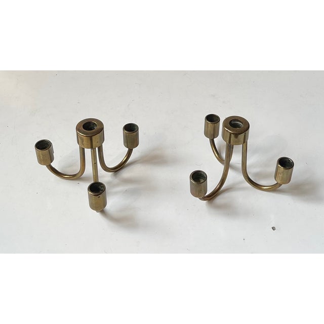 A pair small string candleholders or candelabras. Executed in solid brass that has patinated beautiful over the years. The...