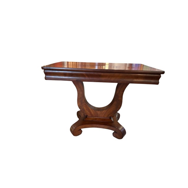 Classic Lexington console table showcasing an elegant Regency-inspired lyre pedestal resting on sculptural scroll feet....