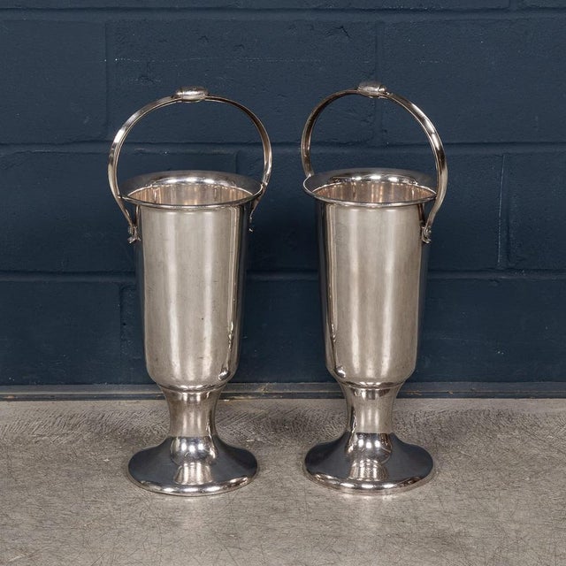 A striking pair of tall, floor-standing wine coolers in polished metal, likely dating to the mid 20th Century and designed...