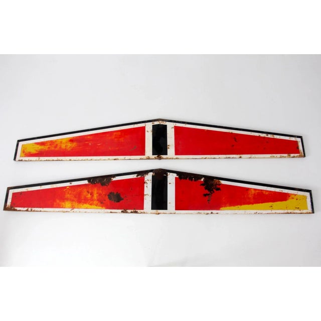 Pair of large vintage metal industrial signs featuring bold red backgrounds with black and yellow lettering. These long...