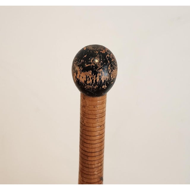A pair of antique eight pound wooden juggling pins with bulbous bodies, fine turned ridges, a decorative black band and...