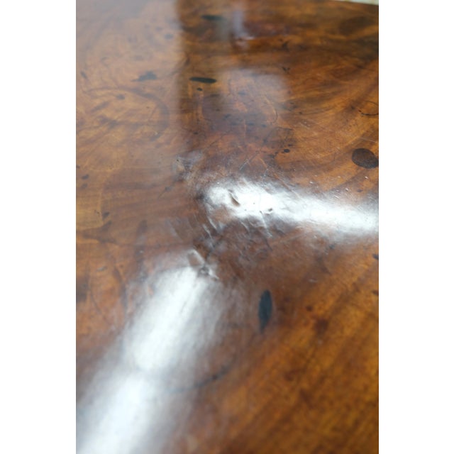 A handsome antique tilt top tea table with brass wheeled feet, from England, dating to the 1820s. Constructed from...