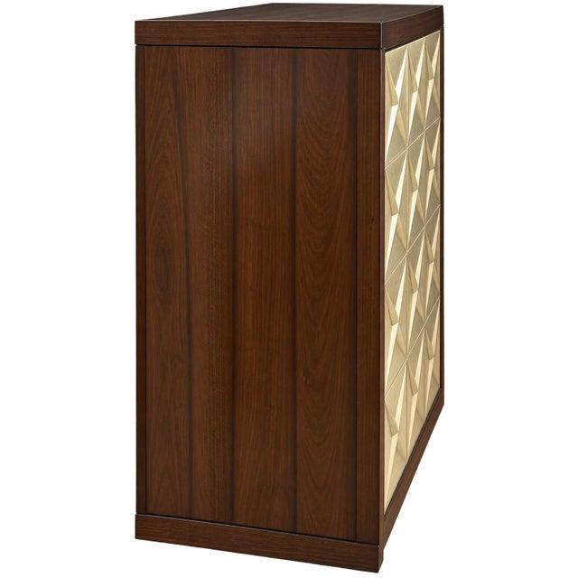The Atelier Cabinet with walnut veneer with warm silver leaf door fronts by the luxury manufacturer Bolier & Co. Behind...