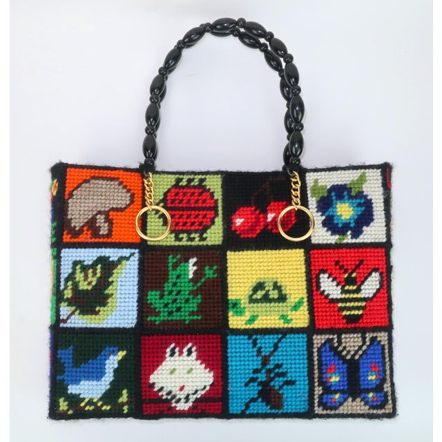1970’s needlepoint tote handbag crafted from a kit designed by Bob Miller entitled ‘Ecology’. The colorful grid features...