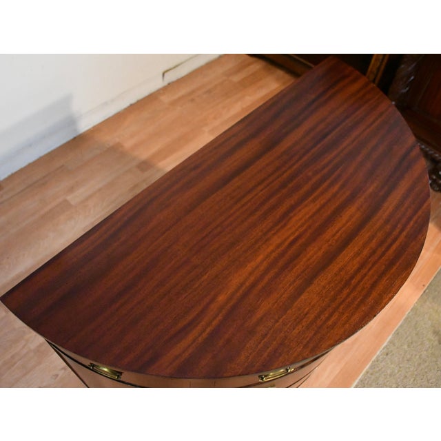 We are pleased to offer this beautiful English Regency Demi-lune, from the 1920s. Made of Flame Mahogany & banded...