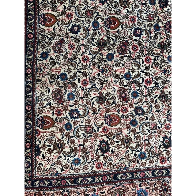 Discover the timeless elegance of our large mid-century Mashhad rug! Adorned with a beautiful floral design in vibrant...
