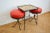 Excellently designed and crafted small coffee table and matching pair of red, three legged stools. Cast iron frames....
