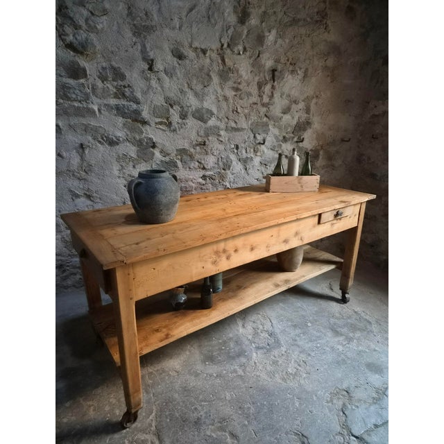 An antique work table dating from the early 20th century, originating from France. Crafted from solid cherry wood with a...
