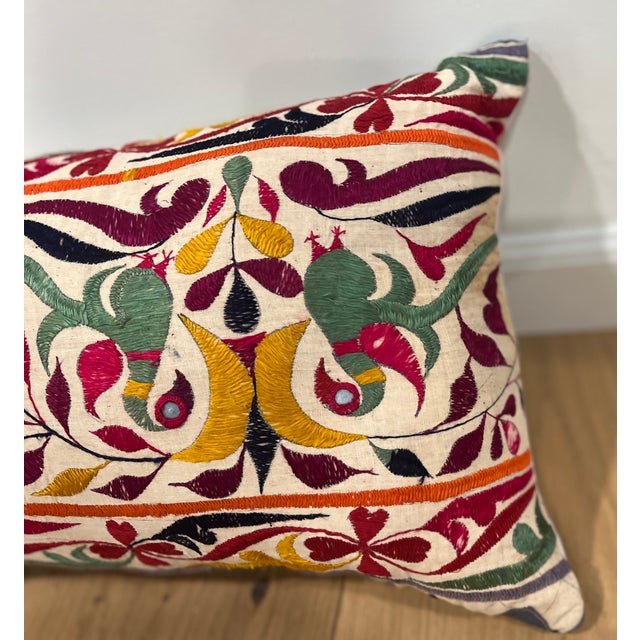Elegant decorative pillow upholstered in a richly patterned Uzbek textile, featuring charming floral flowerhead motifs and...