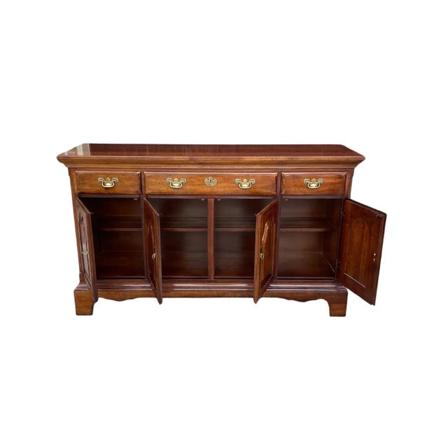 Vintage cherry wood cabinet, sideboard, credenza with a medium-brown finish. It features a rectangular top and stands on...