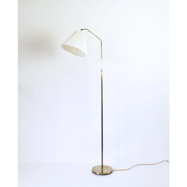 Scandinavian midcentury brass floor lamp. Good condition with a fine patination. Mounted with a pleated shade. Measures:...